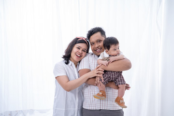 asian young family with little son on white background