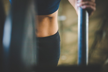 Female fitness model pushing a sled in a cross fit gym.