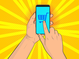 A hand with a smartphone. Finger clicks on the shopping cart icon. Pop Art vintage vector illustration