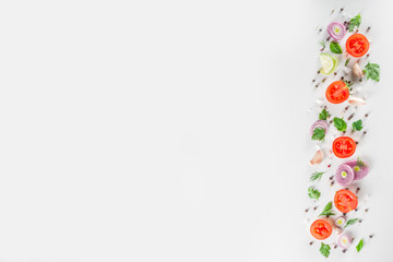 Fresh cherry tomatoes with basil, herbs and spices on white background, copy space for text top view. Ripe raw vegetables flatlay. Cooking food background, simple pattern