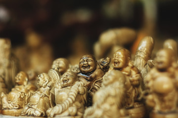 Figurines of the Chinese God Hotei on the counter with Souvenirs. The concept of meditation, happiness, travel.