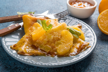 Thin crepes suzette with orange slices and marmalade for breakfast