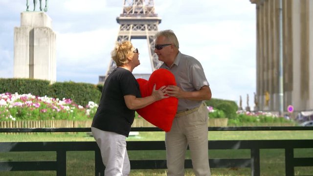 Senior couple in love with huge heart in front of Eiffel tower in 4k slow motion 60fps