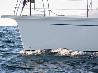 Closeup of white yacht or passenger boat board sailing on sea water