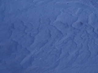 Snow waves at purple sunset background texture closeup