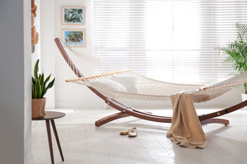 Comfortable hammock with pillows in stylish room. Interior design