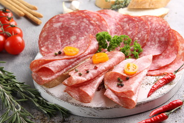 Italian cuisine. Ham and sausage. Sliced meat on a white background. vegetables and bread.Background image. Copy space