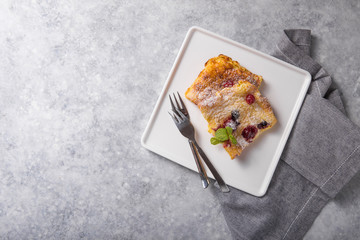 Pannukakku  or Danish pancake with berries topping covered with sugar powder