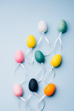 colored plastic eggs arranged on a blue background, top view, conceptual image for easter celebration and spring time.