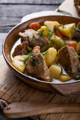 Irish dinner. Beef meat stewed with potatoes, carrots and soda bread on wooden background, top...