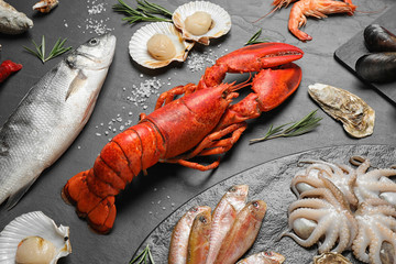 Fresh fish and different seafood on black table