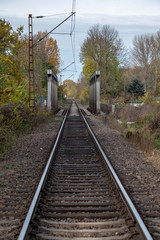 Germany,Autumnal view of a single-track electrified railway line with a bridge