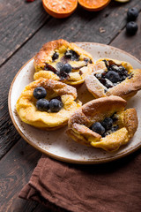 Pannukakku  or Danish pancake with berries topping covered with sugar powder