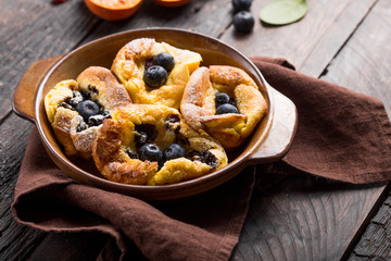 Pannukakku  or Danish pancake with berries topping covered with sugar powder