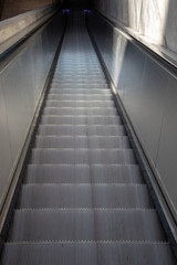 A View of long escalators with stainless steel cladding and exposed concrete walls