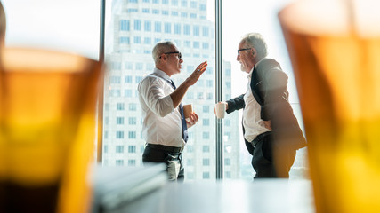 Meeting and discussion concept.business people communicating in office.Mature businessman discuss information with a colleague in a modern business lounge high up in an office tower.