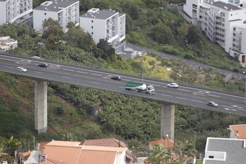 aerial view on houses in the city with highway bridge in funchal at madeira island