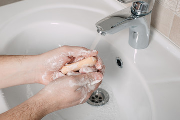 Wash hands under the tap with soap. Hygiene concept in detail. Beautiful stream of hands and water...