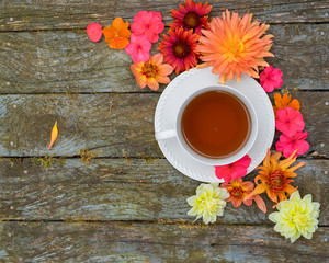 A fresh cup of tea with dahlia, impatiens and gaillardia flowers.