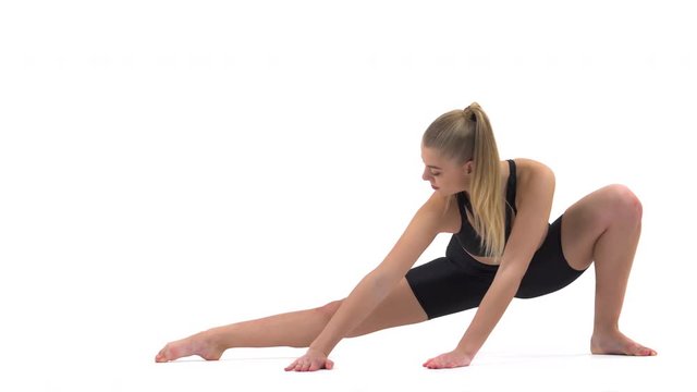Woman having training. Fit girl stretching legs during the training. Young woman performing stretching exercise