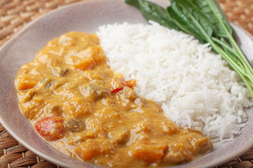 Tasty rice and curry on bamboo plate.