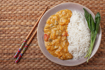 Tasty rice and curry on bamboo plate.