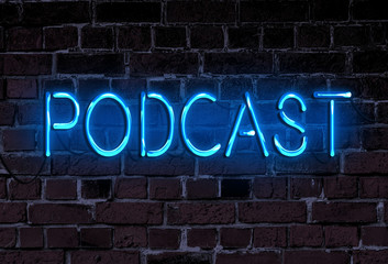 word PODCAST in glowing neon letters on rough brick wall, podcasting recording neon sign