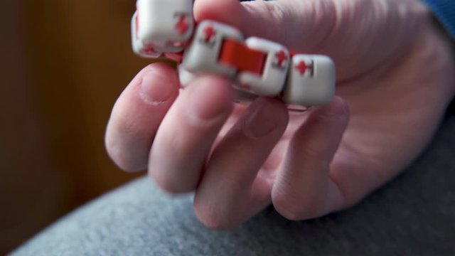 Colorful fingers antistress fidget cube toy in hand of little boy. development of fine motor skills of fingers of children