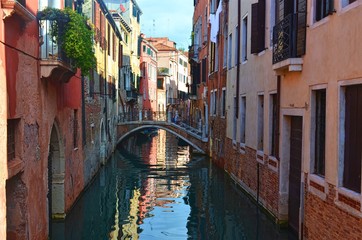 Fototapeta na wymiar quiet small Venetian canal with a bridge between the houses