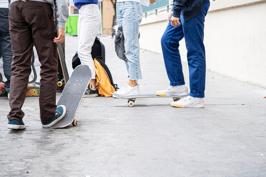 Low section of friends with skateboards standing outdoors