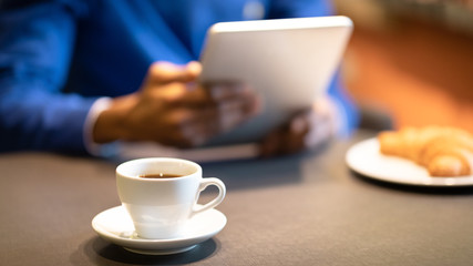 Black man sitting in coffee shop drinking cup of tea
