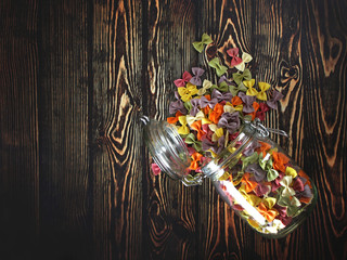 Dry colorful Italian pasta farfalle or bows with glass jar