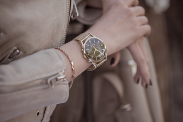 Stylish golden watch on woman hand. - obrazy, fototapety, plakaty