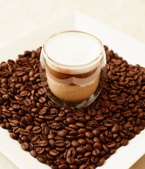 A cup of coffee in coffee beans. Coffee background