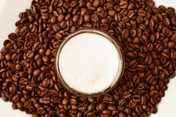 A cup of coffee in coffee beans. Coffee background