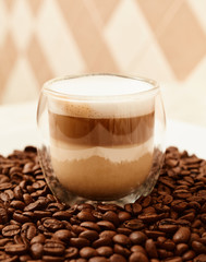 A cup of coffee in coffee beans. Coffee background
