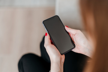 woman holding and looking at phone with blank copyspace screen