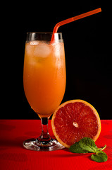 Grapefruit juice with ice in a steamed glass. A steamed glass of ice. Juice with ice. Slice of grapefruit in a glass of juice.