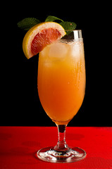 Grapefruit juice with ice in a steamed glass. A steamed glass of ice. Juice with ice. Slice of grapefruit in a glass of juice.