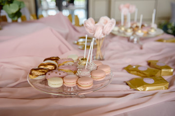 Candy bar served with macaroons, choux pastry and cake pops in restaurant, copy space. Dessert table for party  pink color. Holiday concept