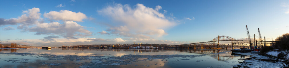 Beautiful Panoramic View of Fraser River and Pattullo Bridge in the City during a cold and icy winter sunset. Taken in New Westminster, Vancouver, British Columbia, Canada.
