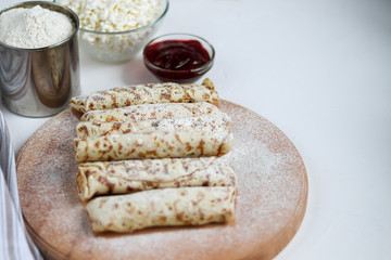 Raw pancakes with homemade cottage cheese. Sour-milk fermented product. Healthy, delicious breakfasts. On a wooden board.