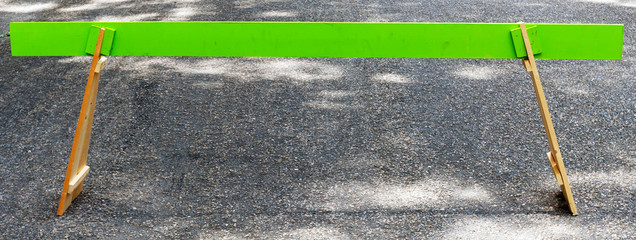 Wooden green traffic barrier on street.