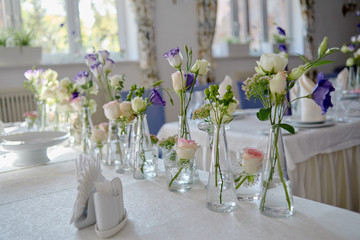 Beautiful floral arrangement on wedding table in restaurant, copy space. Bouquet of pink roses,...
