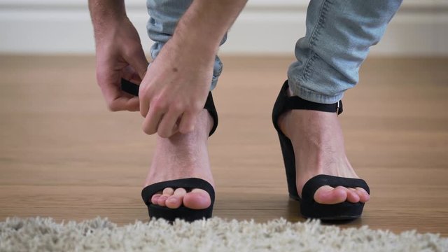 Close-up of male Caucasian feet entering the shot, man taking off high heels, and leaving. Demonstration of intersex people self identification.