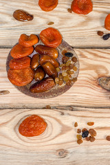 Tasty dates, raisins and dried apricots on a wooden table. Top view