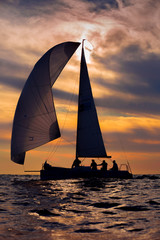 Orange romantic sunset with silhouette of yacht