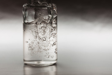 Macro photo of bottle with fluid collagen of hyaluronic acid