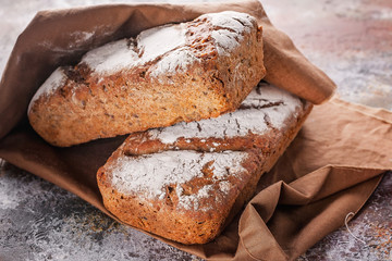 Close up freshly baked sourdough bread with sunflower and pumpkin seeds on a brown napkin.