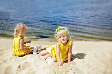 Adorable childs in dress posing outdoors. Little baby girls relaxing by the sea. Girls having fun together. Concept of summer,childhood and leisure